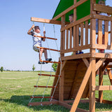 A complete set of wooden mountain-style swings, equipped with a colorful canvas sunshade, a wave slide, a rope swing, a net swing, and a rock wall with climbing ropes and ladders.